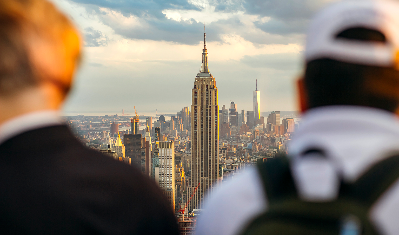 People looking out at the Empire State Building from an observation deck