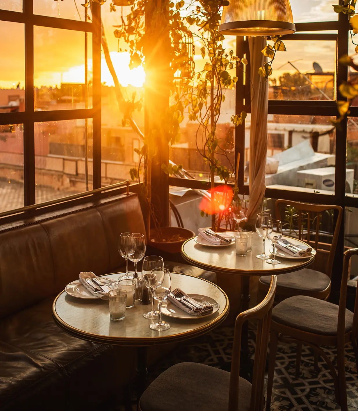 Sunlit restaurant terrace with set tables at golden hour