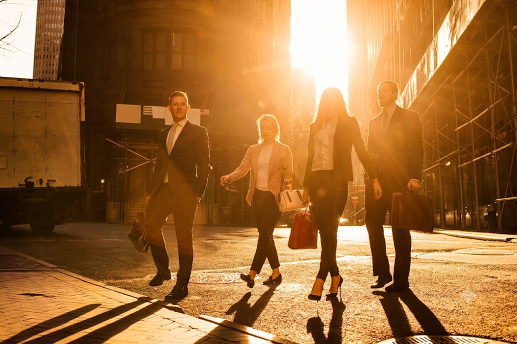 Business professionals walking down a city street at sunrise