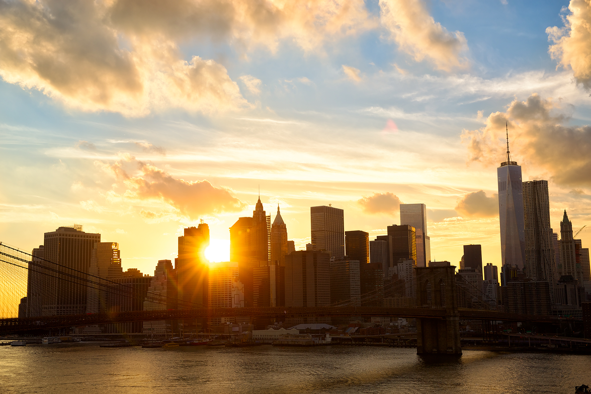 Sun setting behind the Lower Manhattan skyline across the East River