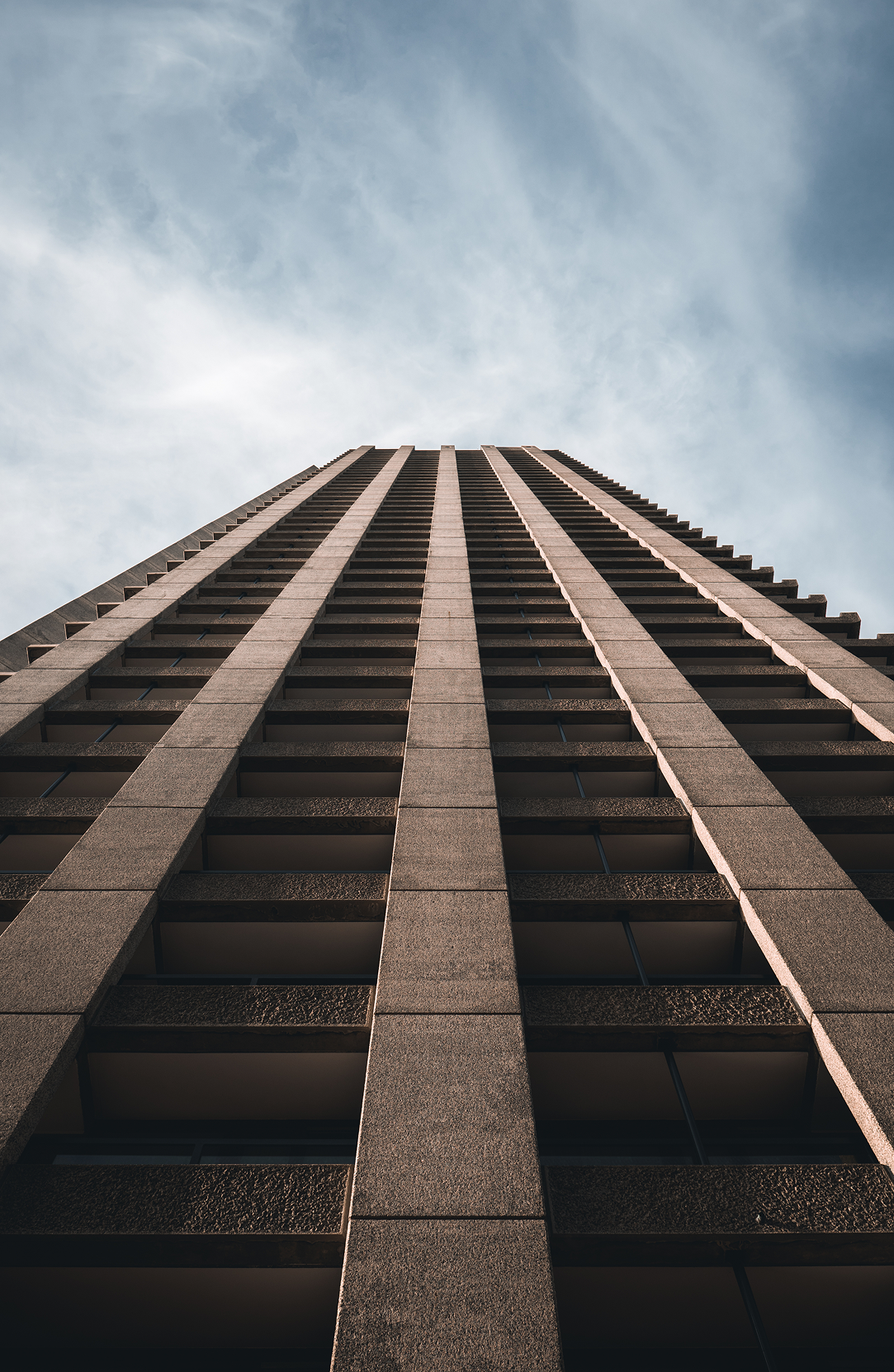 Looking up at a tall concrete office tower