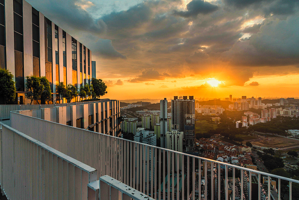 Rooftop terrace overlooking a city at sunset