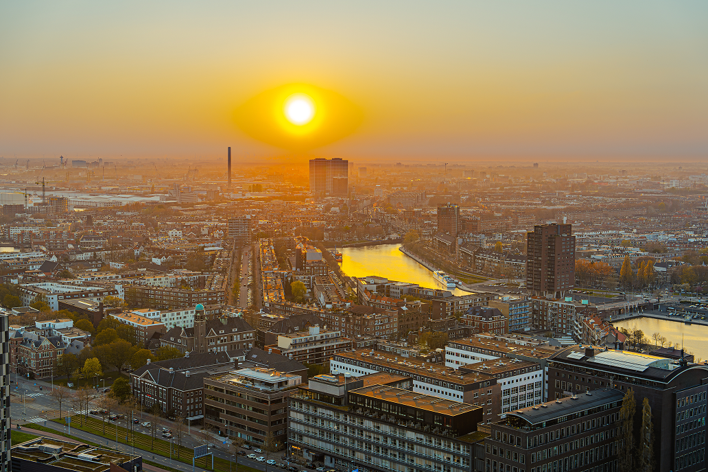 Sun setting over a city skyline and river