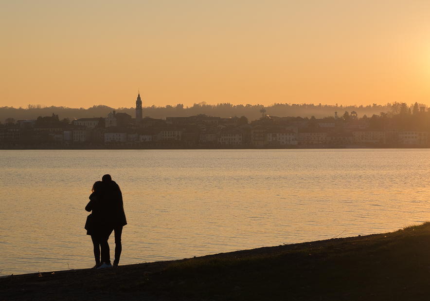 Couple embracing by the water at sunset