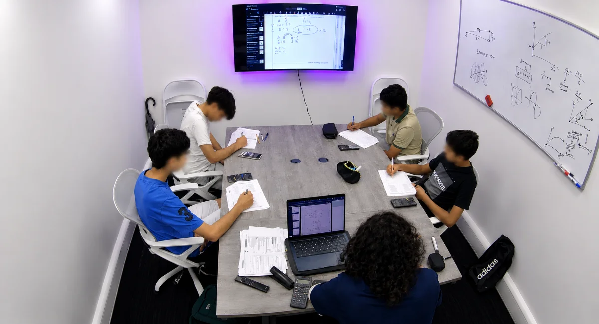 Students working through past papers around a table in a tutoring room