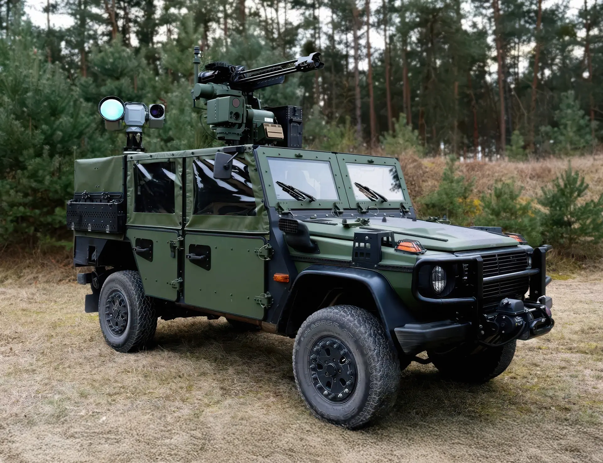 Military green armored vehicle equipped with mounted radar systems parked on grass with pine trees in the background.