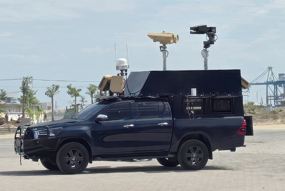 Black pickup truck equipped with multiple surveillance cameras and sensors on its roof and sides.