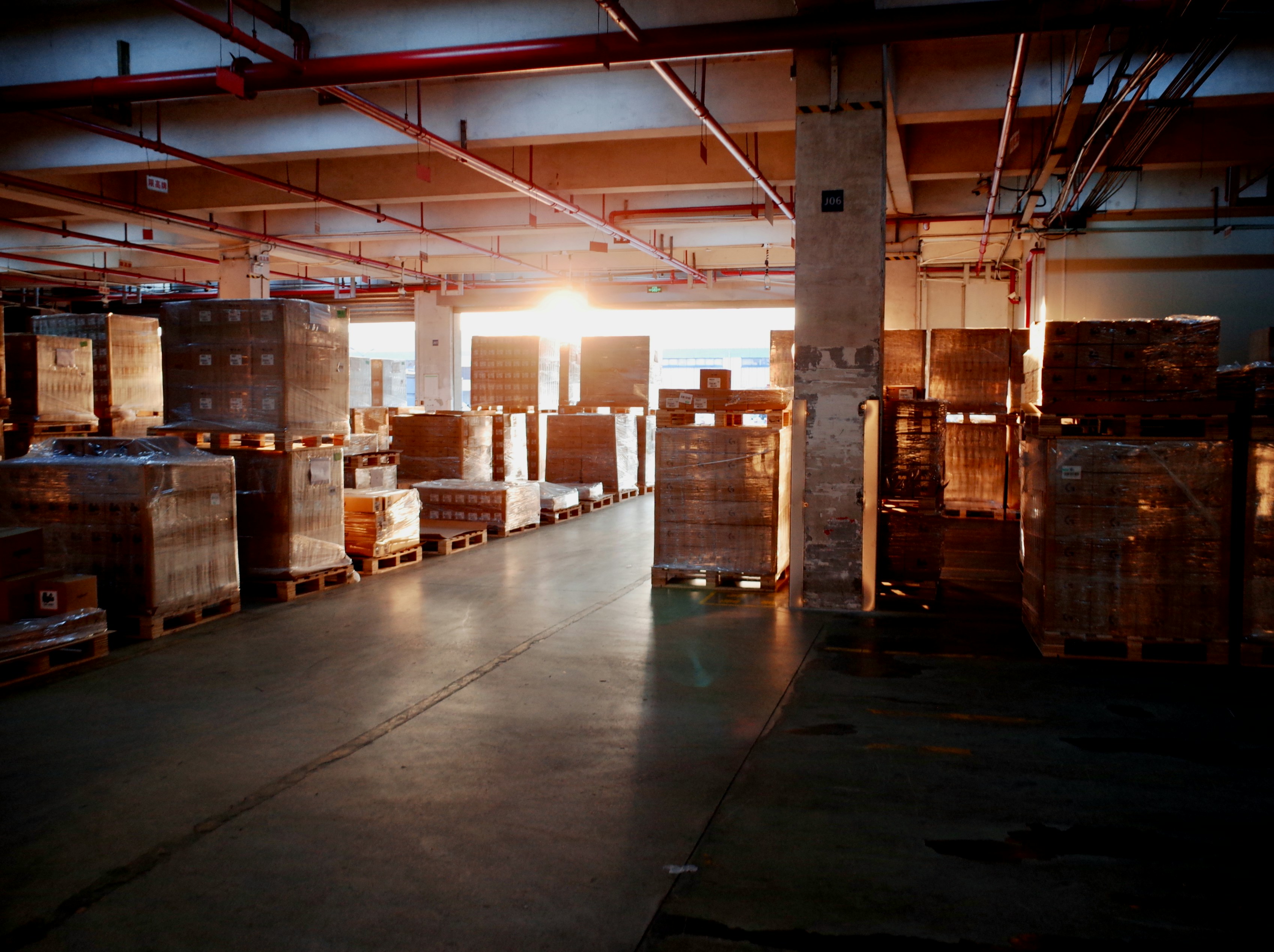 Interior of a warehouse aisle stacked with palletized inventory