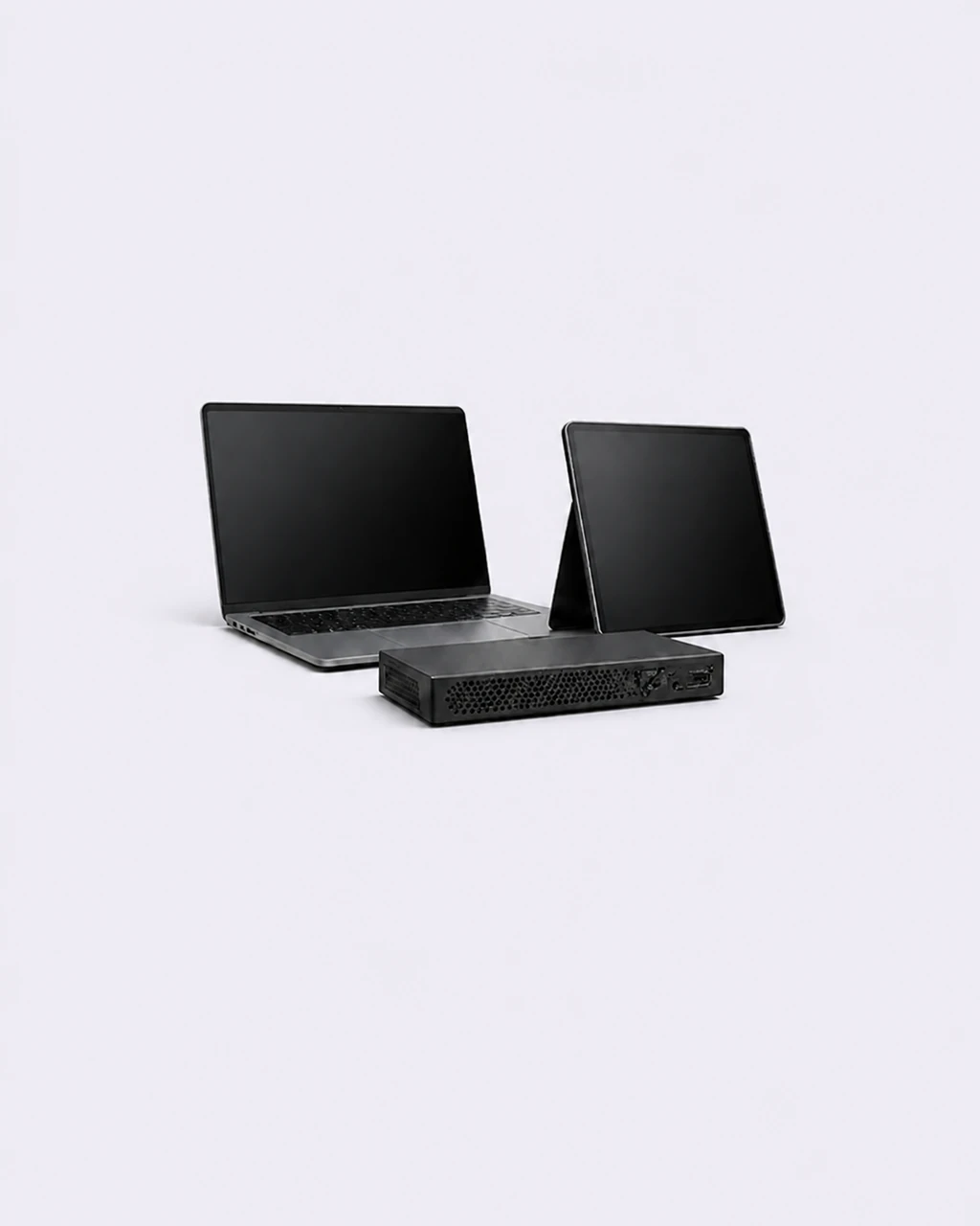 Laptop, tablet and compact media server against a light grey-purple background
