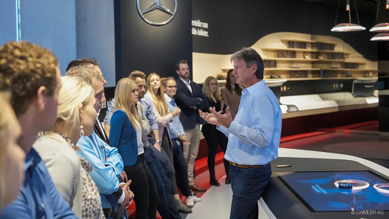 Visitor group at an interactive AV table in the Daimler Brand Space.