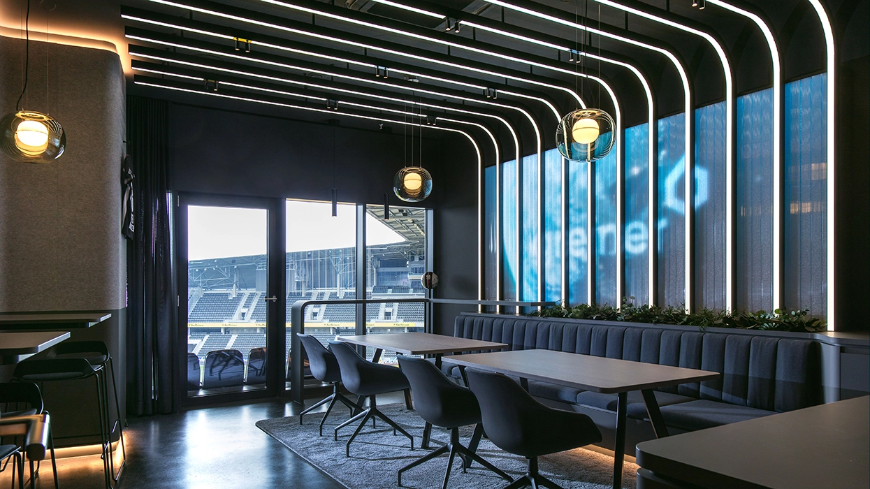 A restaurant interior with a large screen on the wall.