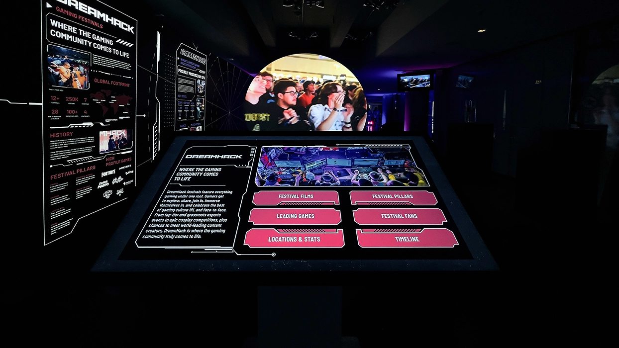 An interactive display with images of people in a dark room.