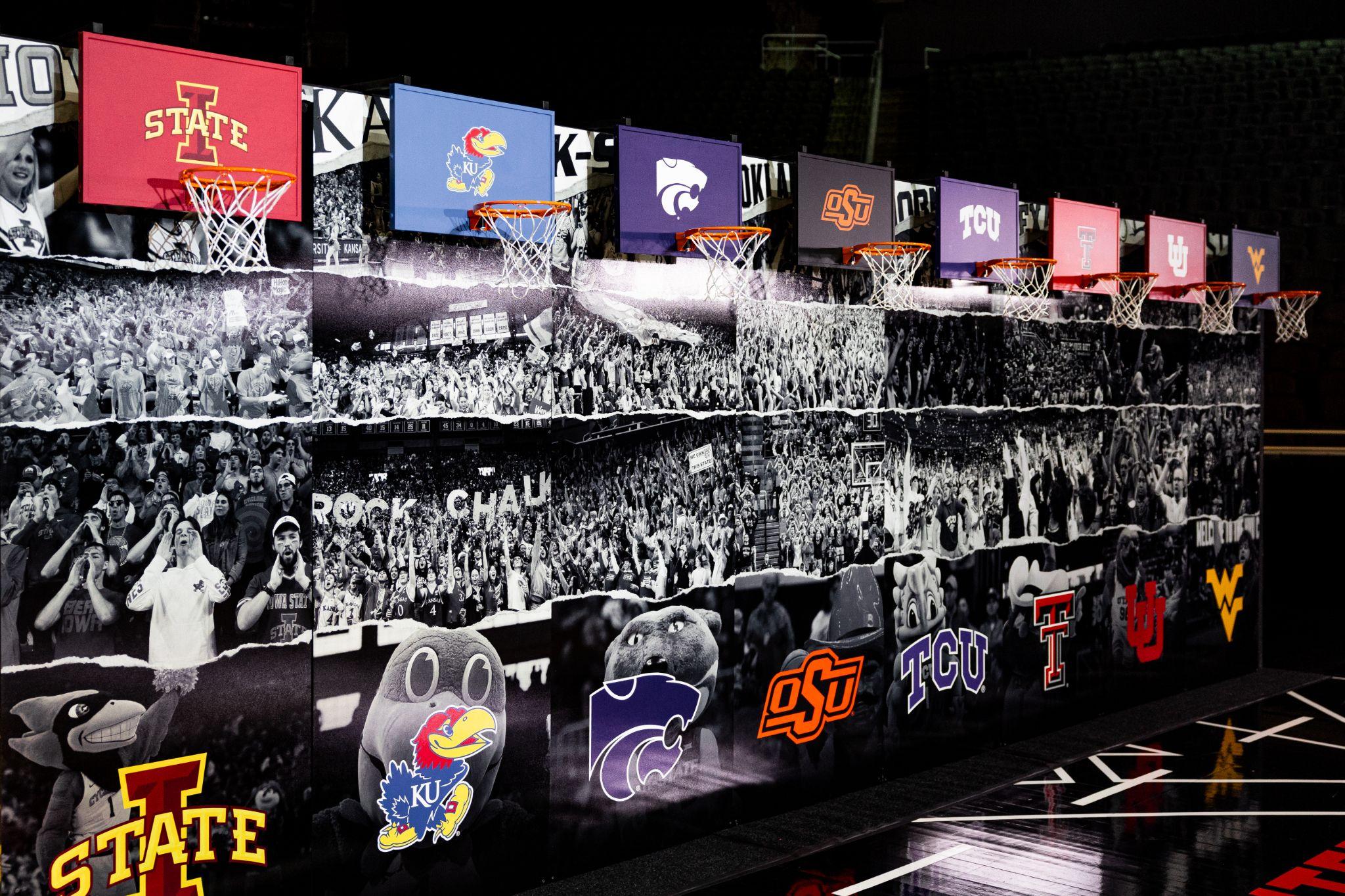Wall of team hoops and school logos for each Big 12 program above a crowd mural