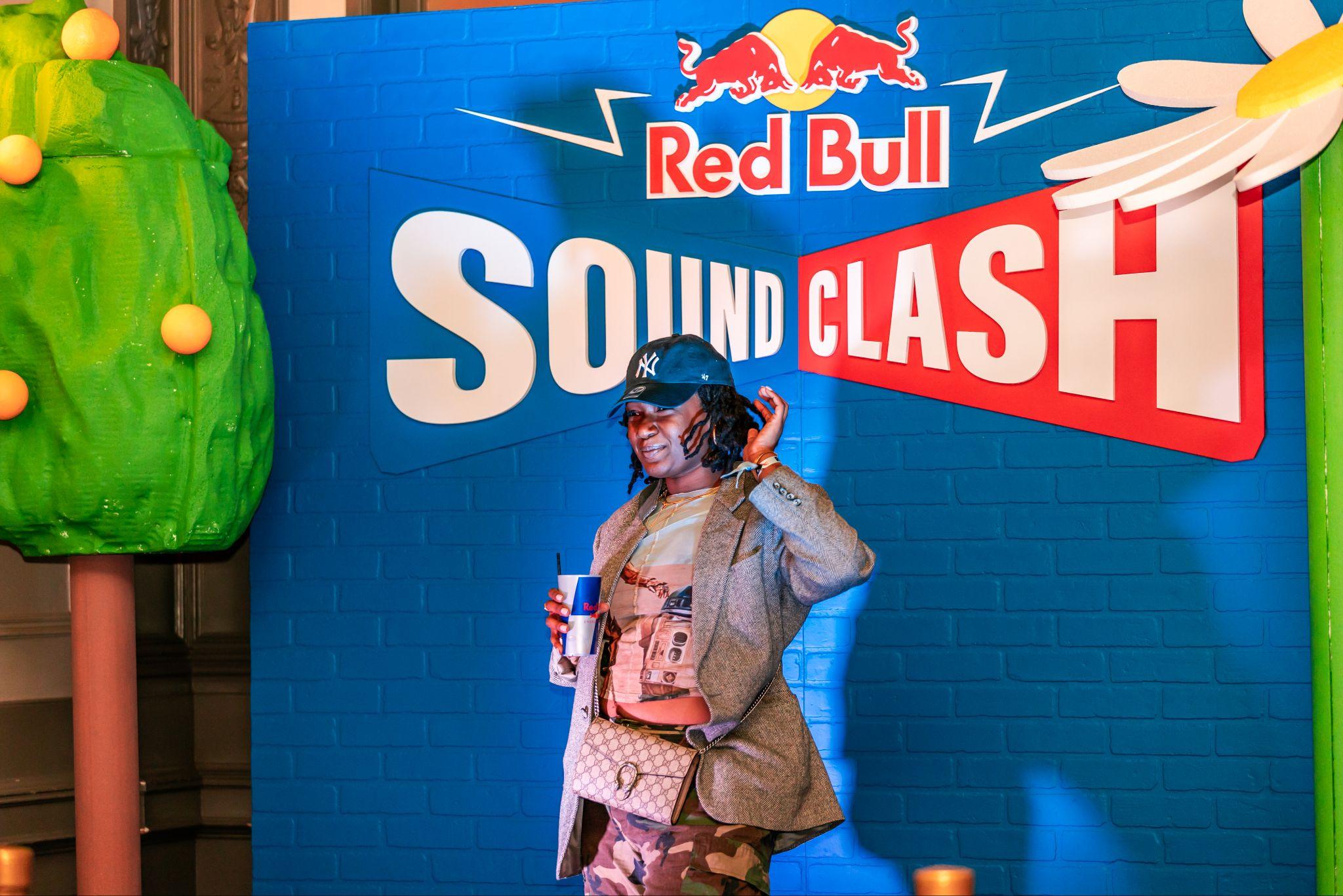 Guest poses in front of the Red Bull Soundclash photo wall