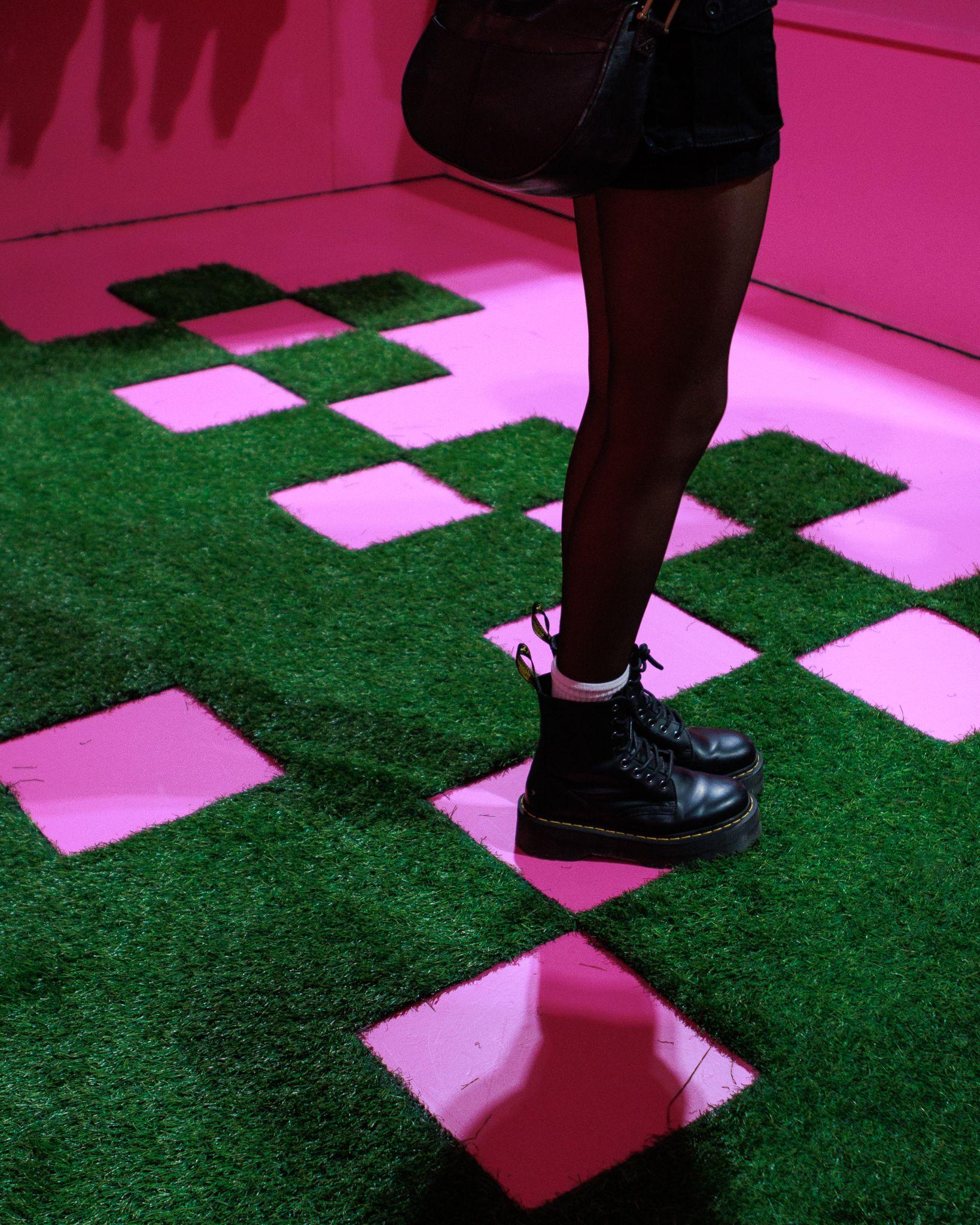 Pink and turf checkerboard floor inside the Members of the Rage install