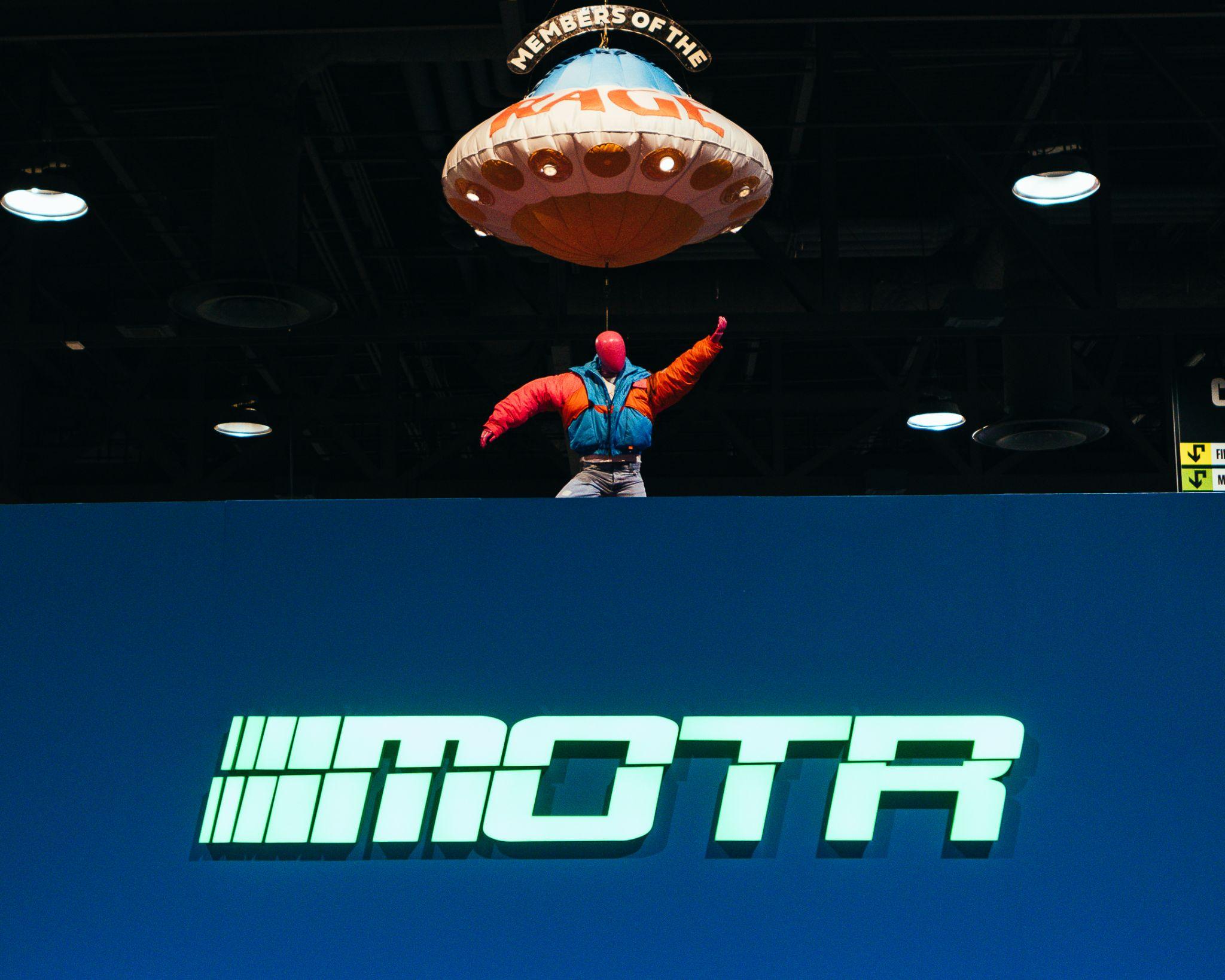 Figure suspended beneath a UFO above the Members of the Rage booth at ComplexCon