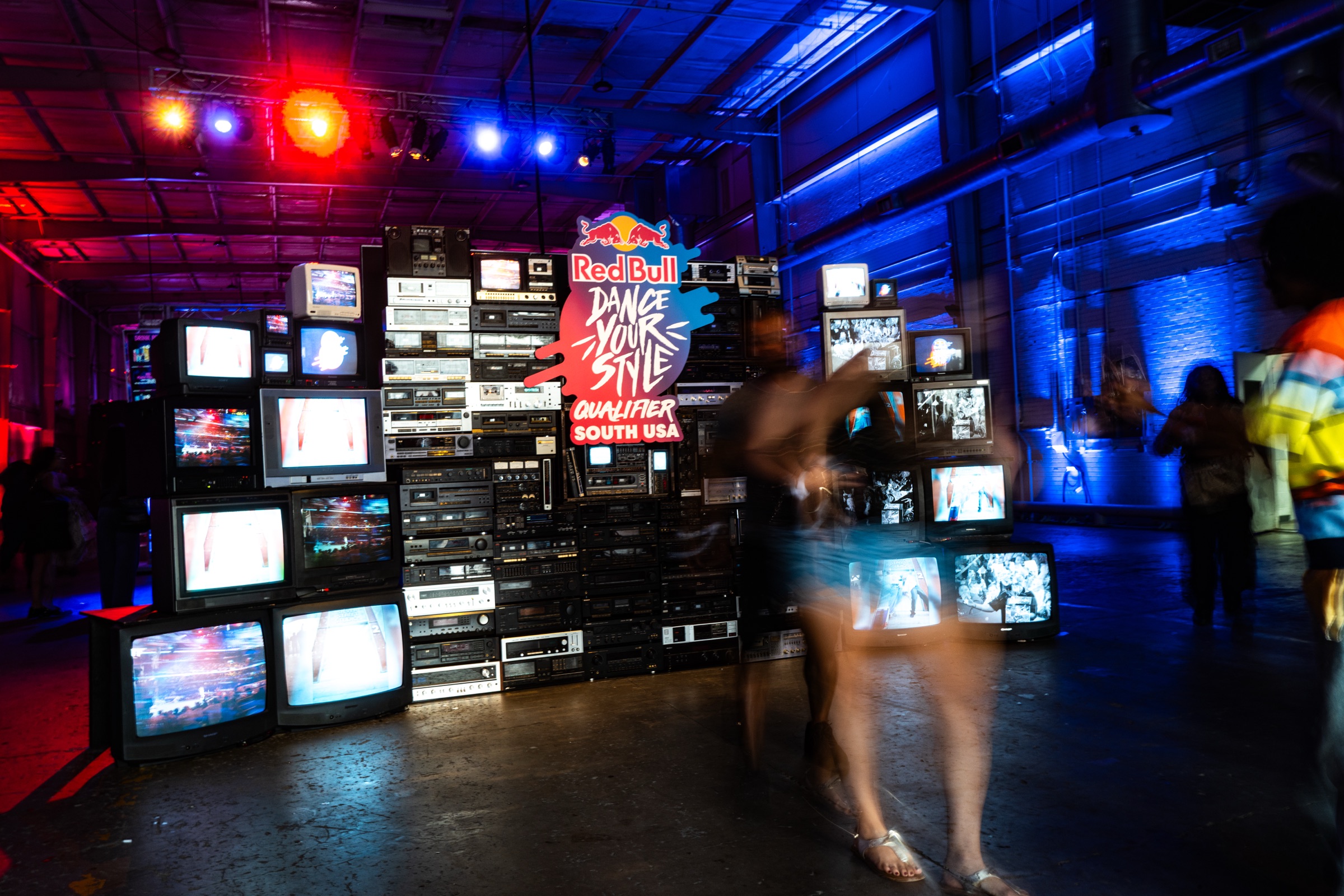 Wall of vintage TVs beside a dancer in the Red Bull Dance Your Style venue
