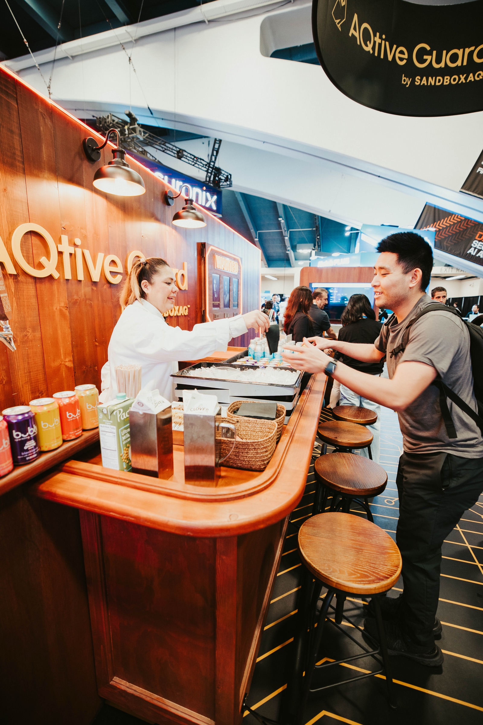 Bartender serving visitors at the saloon bar inside the SandboxAQ booth