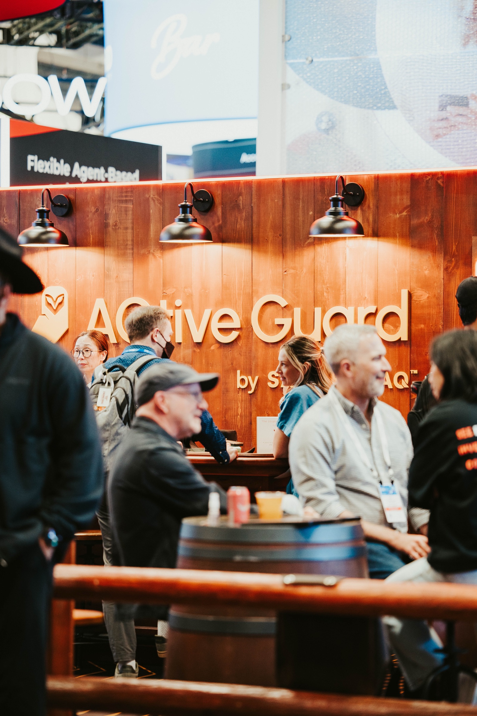 Meeting space with barrel tables under the AQtive Guard sign