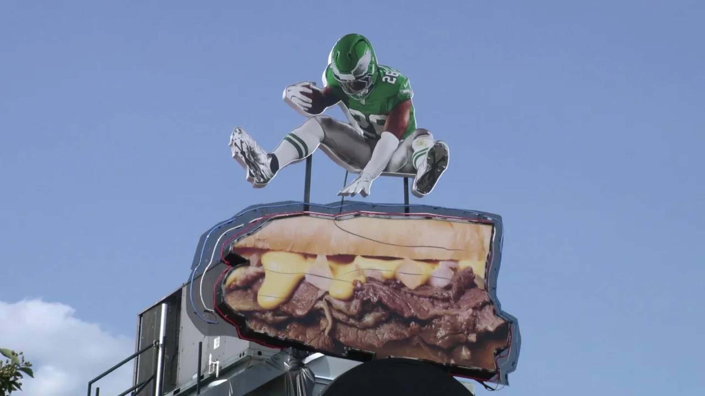 Rooftop sculpture of Saquon Barkley hurdling a giant cheesesteak