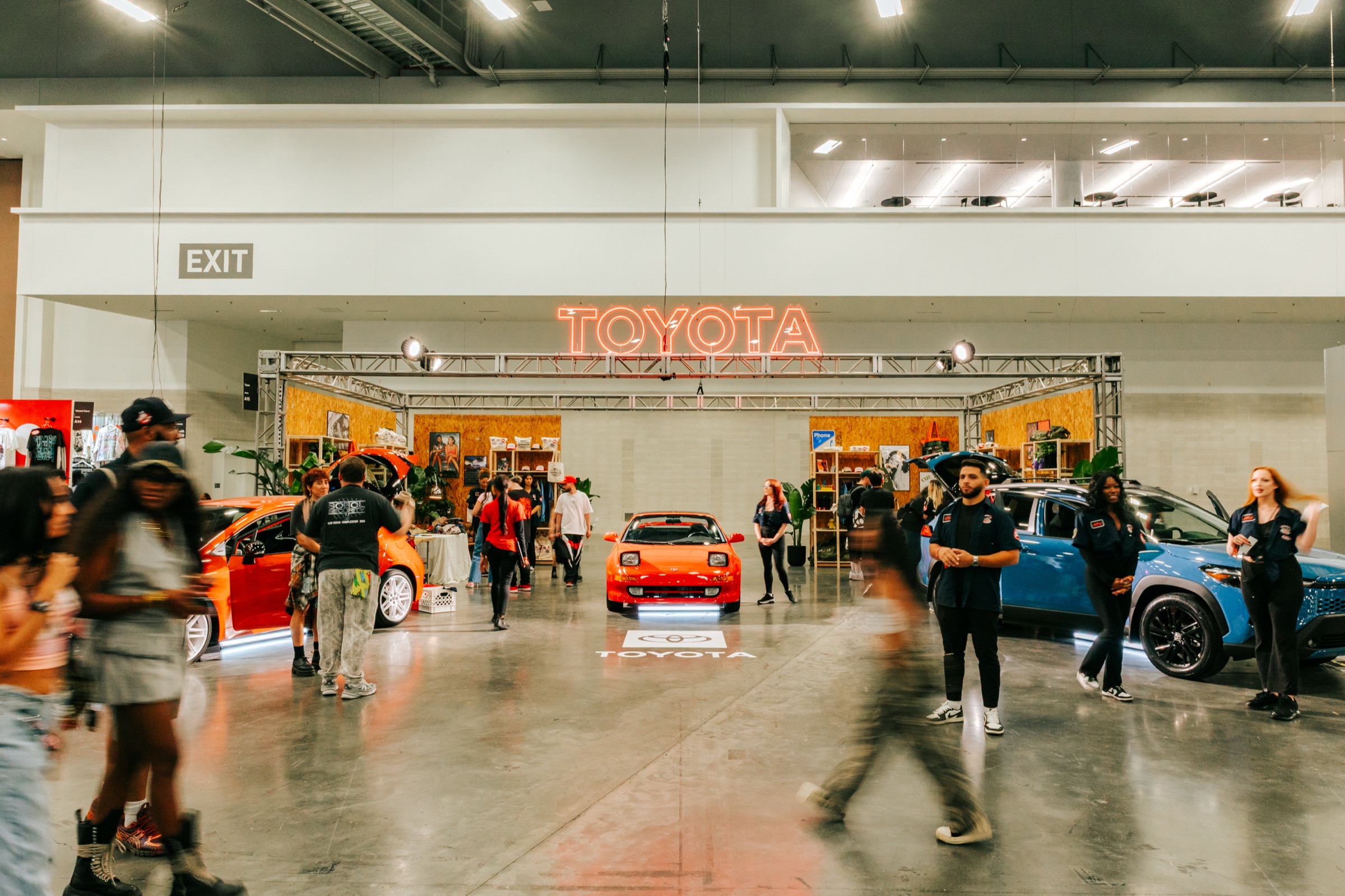 Toyota's '90s vintage garage booth at ComplexCon 2025 with cars under a neon Toyota sign