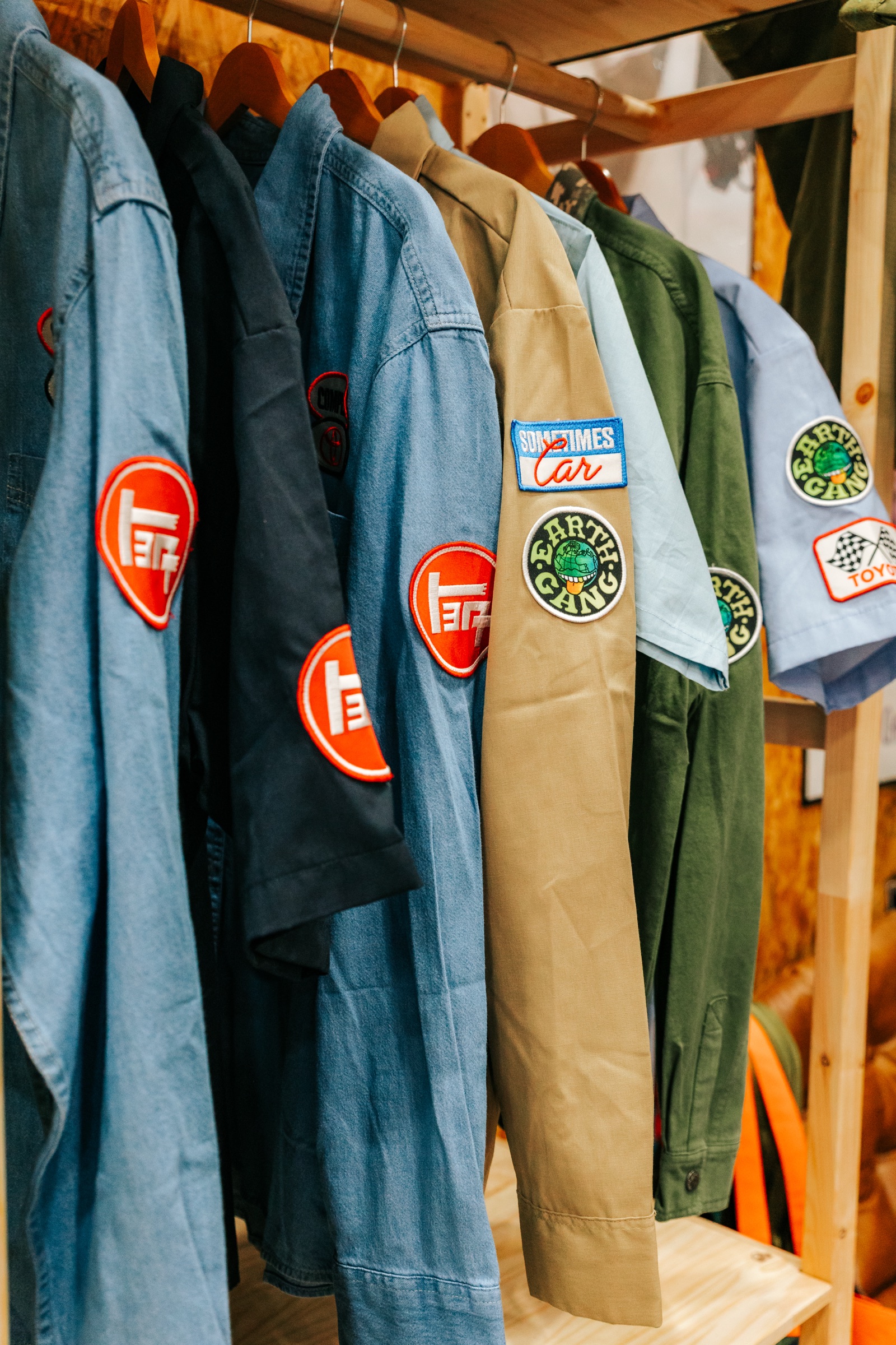 Vintage work jackets with Toyota patches on a wooden rack