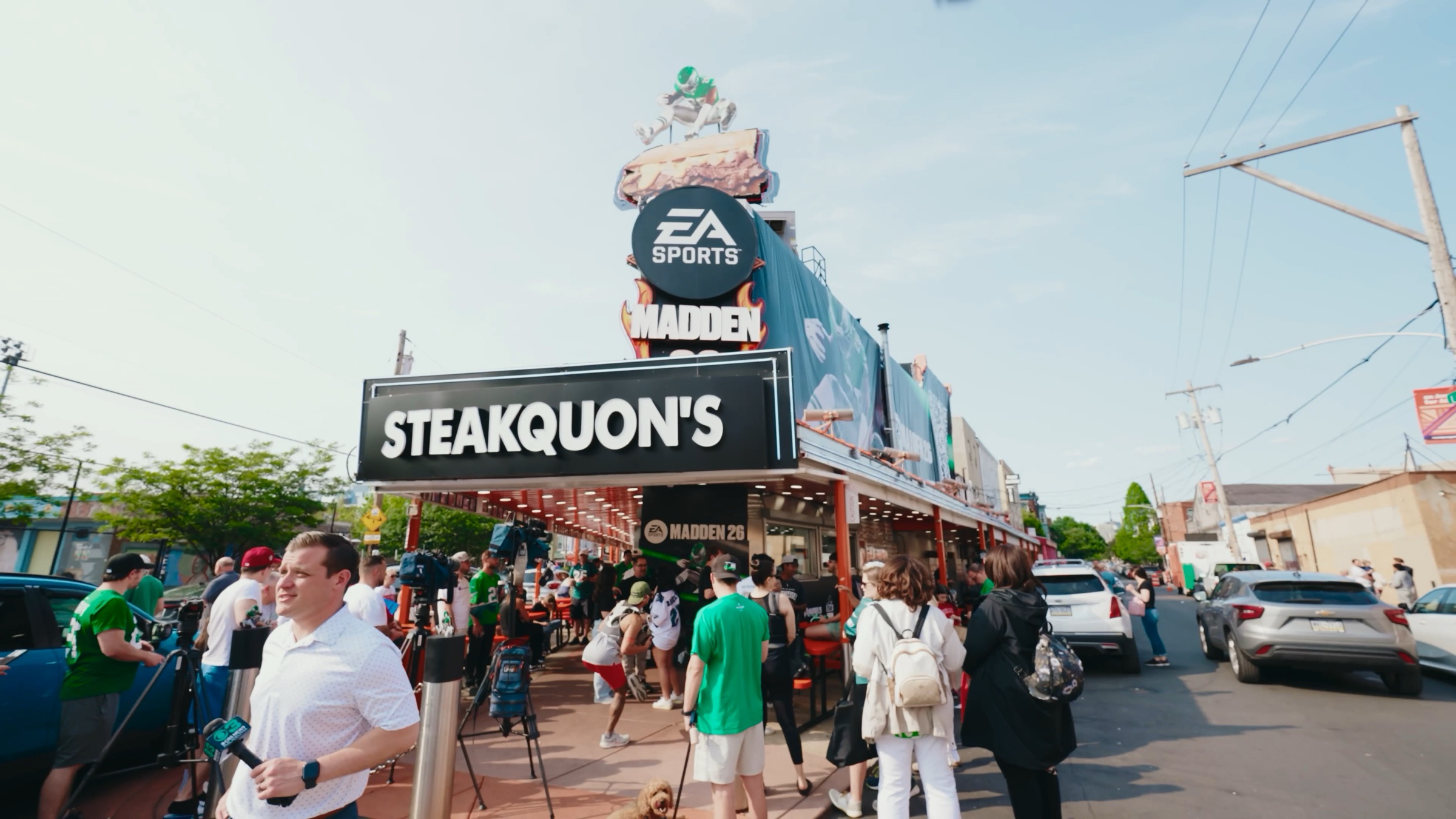Crowd and cameras outside Steakquon's for the Madden NFL 26 cover reveal in Philadelphia