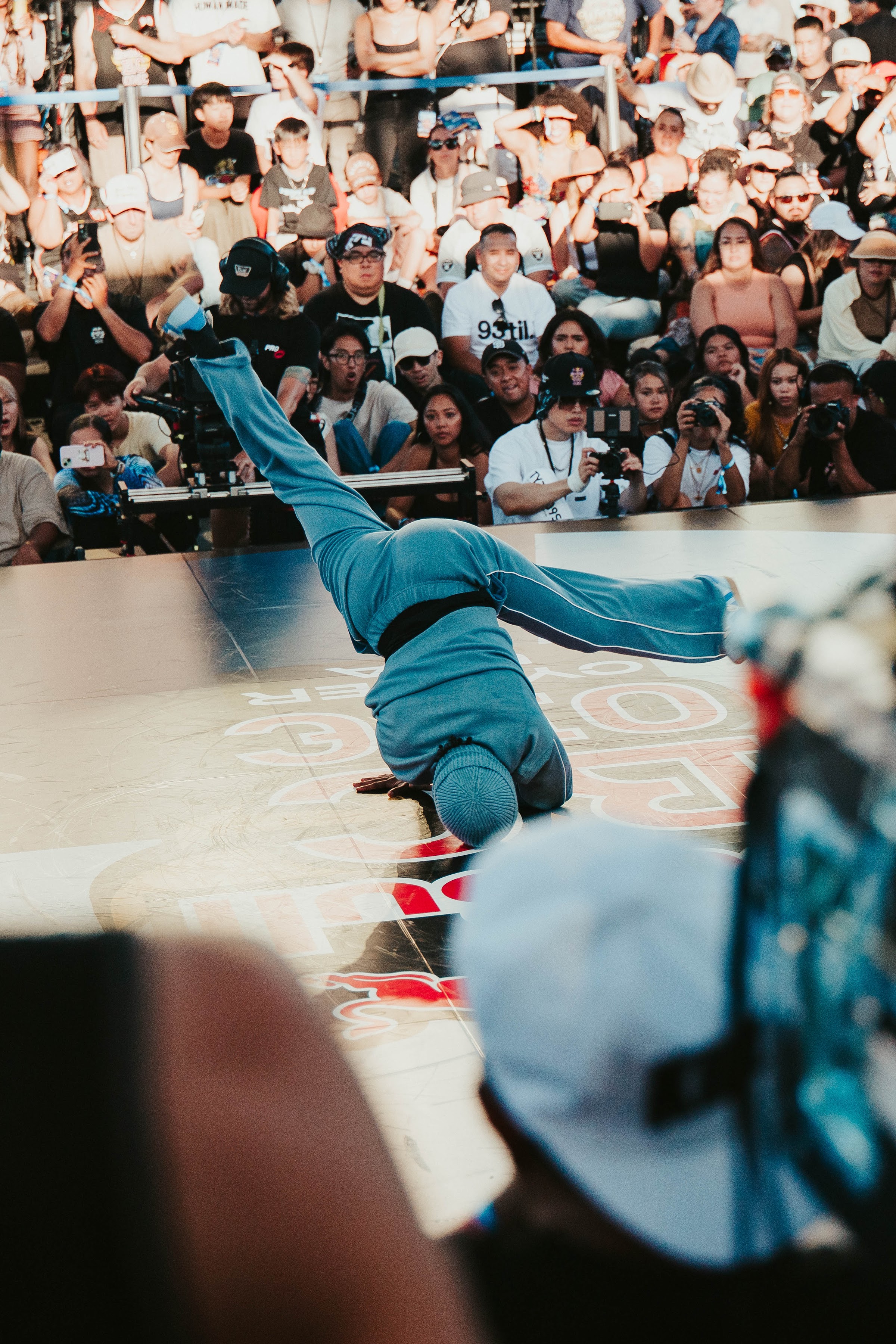 Breaker holds a handstand freeze in front of photographers and fans