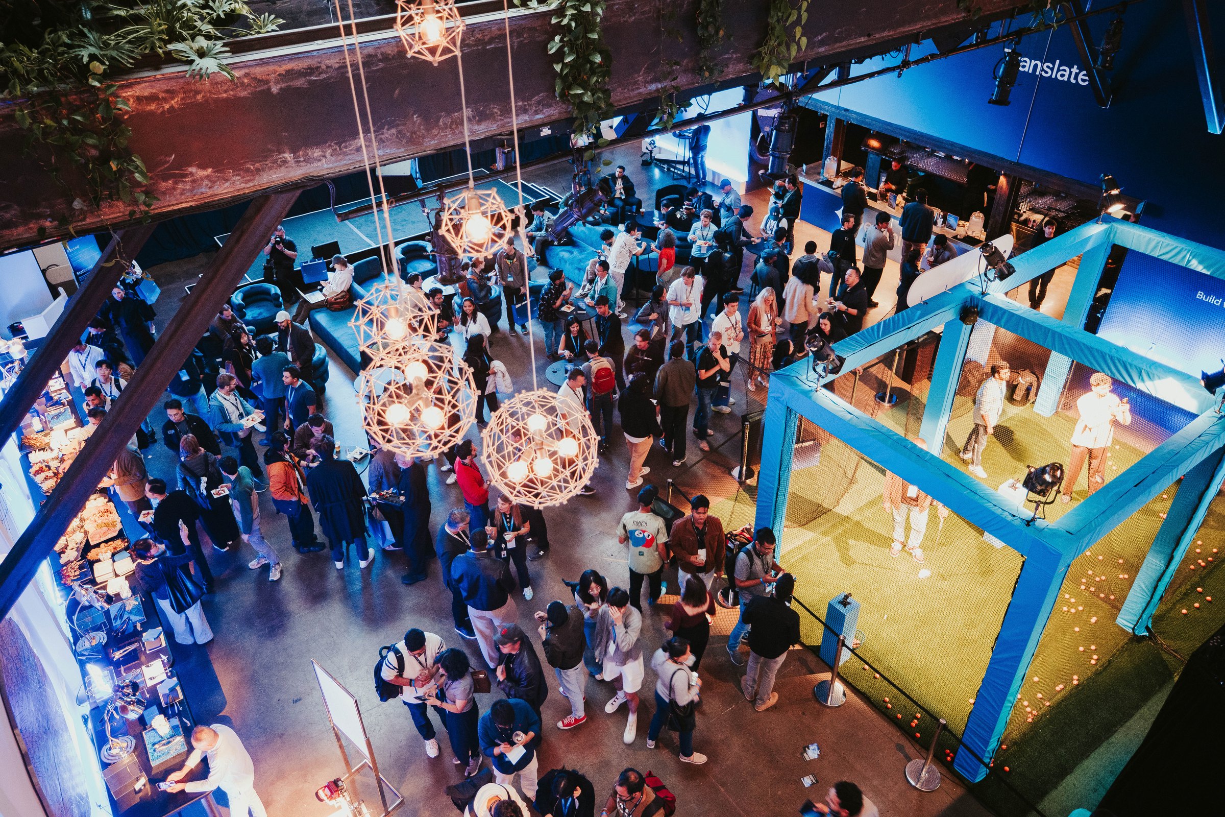 Overhead view of the crowd, pendant lights and Audio Range golf cage at Gemini Audio, The Pearl, San Francisco