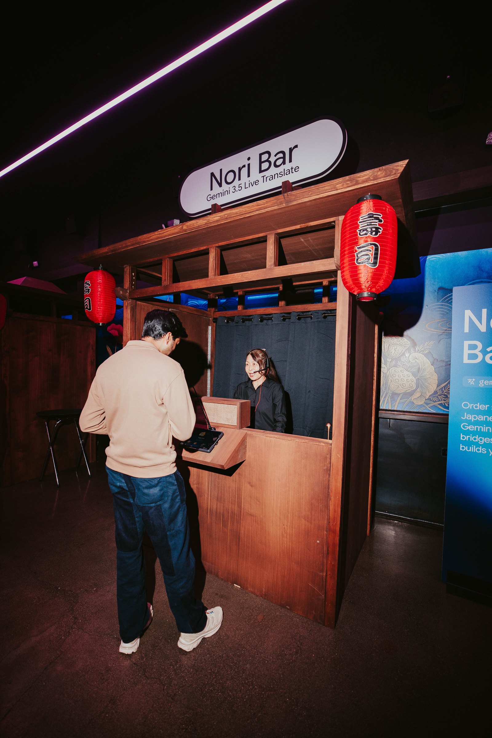 A guest voice-orders a hand roll at the Nori Bar, built around Gemini Live Translate
