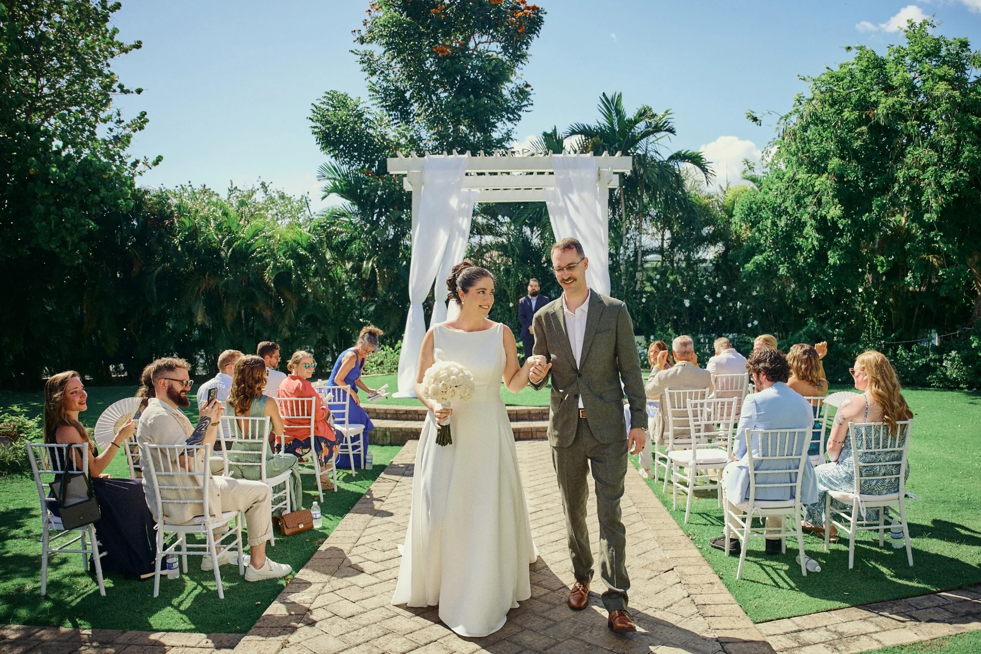 Newlyweds walking down the aisle after a garden ceremony in Jamaica