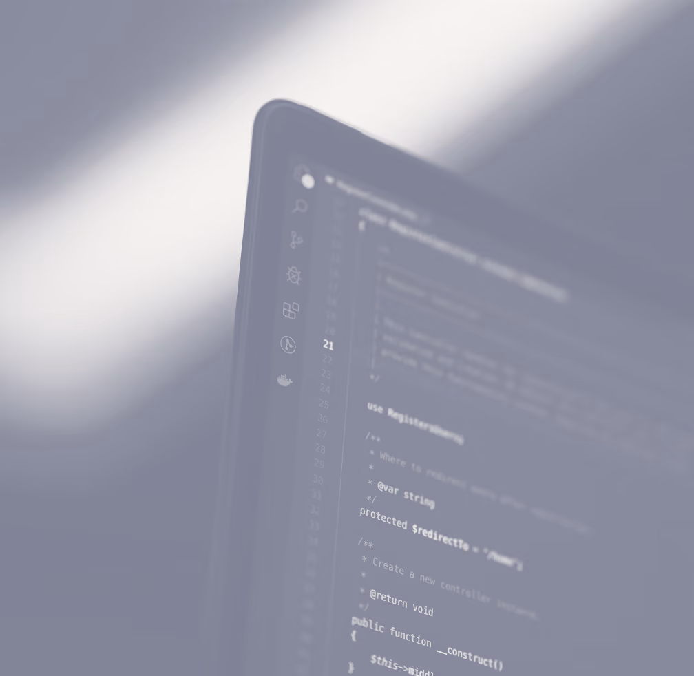 Blurred close-up of a computer screen displaying lines of programming code with light and shadows cast across it.