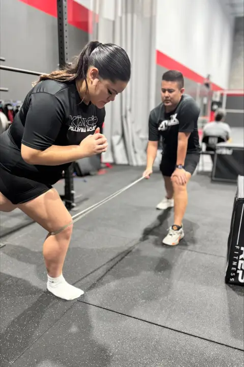 Athlete performing a strength and conditioning exercise with a coach at ATHLTX Sports Performance in Waipahu, HI.