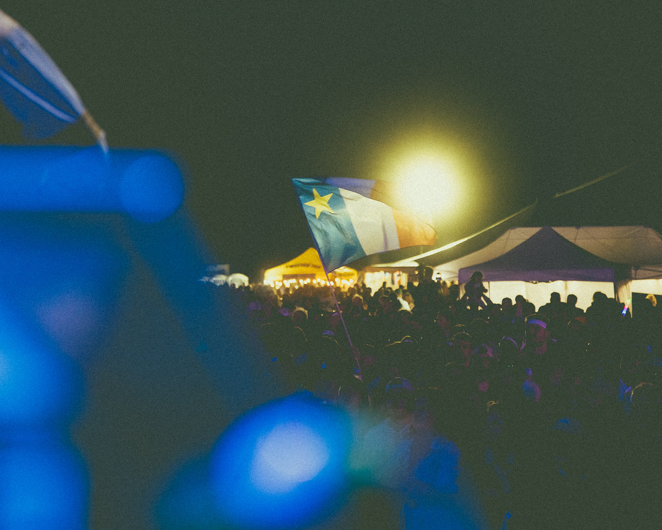 Le drapeau acadien flottant au-dessus de la foule lors d'un concert en plein air du groupe Beauxmont.