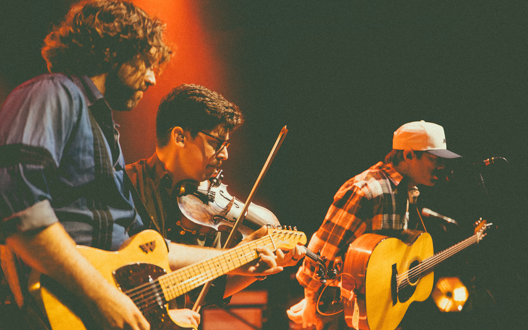 Patrick Dugas à la guitare électrique, Justin Doucet au violon et Félix à la guitare acoustique et voix en concert avec le groupe Beauxmont.