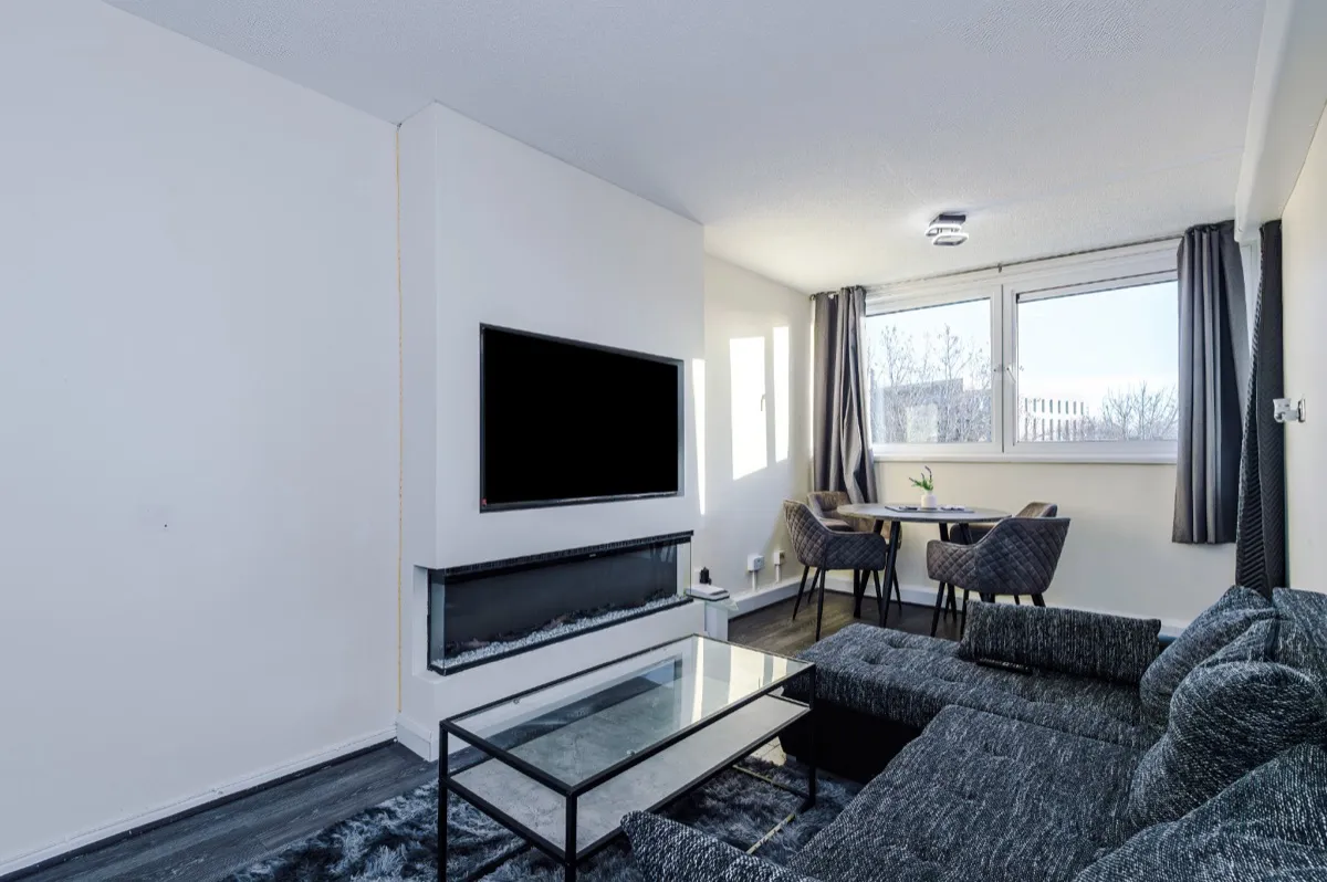 A modern living room with feature fireplace in a Hulme short-let managed by Kammili Properties