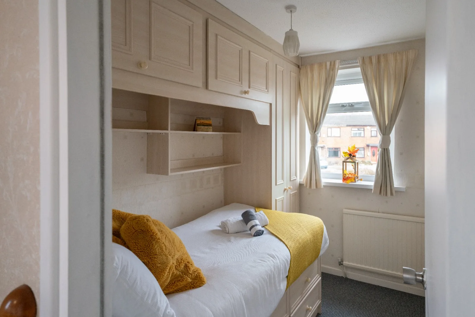 Single bedroom with overhead storage and a street-facing window at Old Vicarage in Westhoughton, Bolton