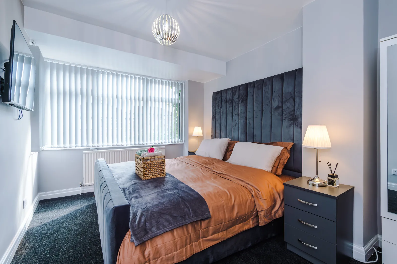 Main bedroom with a tall velvet headboard and bay window at 3 Albert Gardens