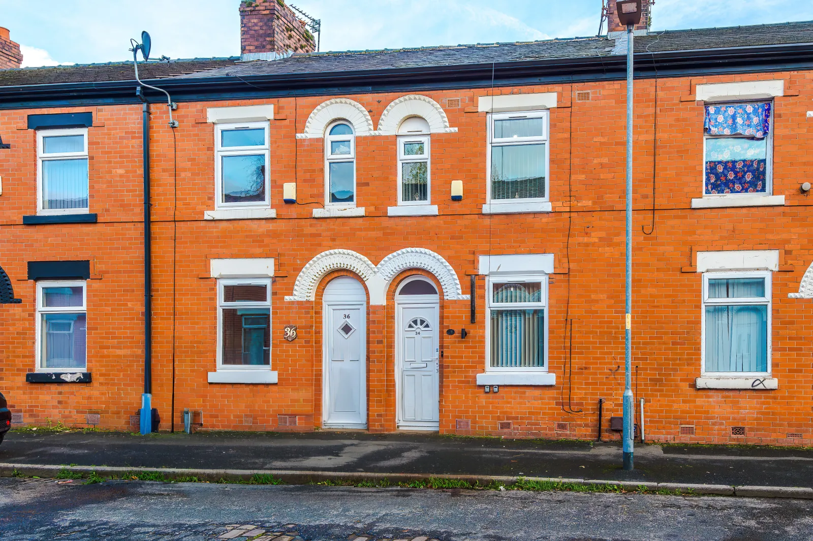 The red-brick terraced exterior of 34 Beeston Street in Harpurhey, Manchester