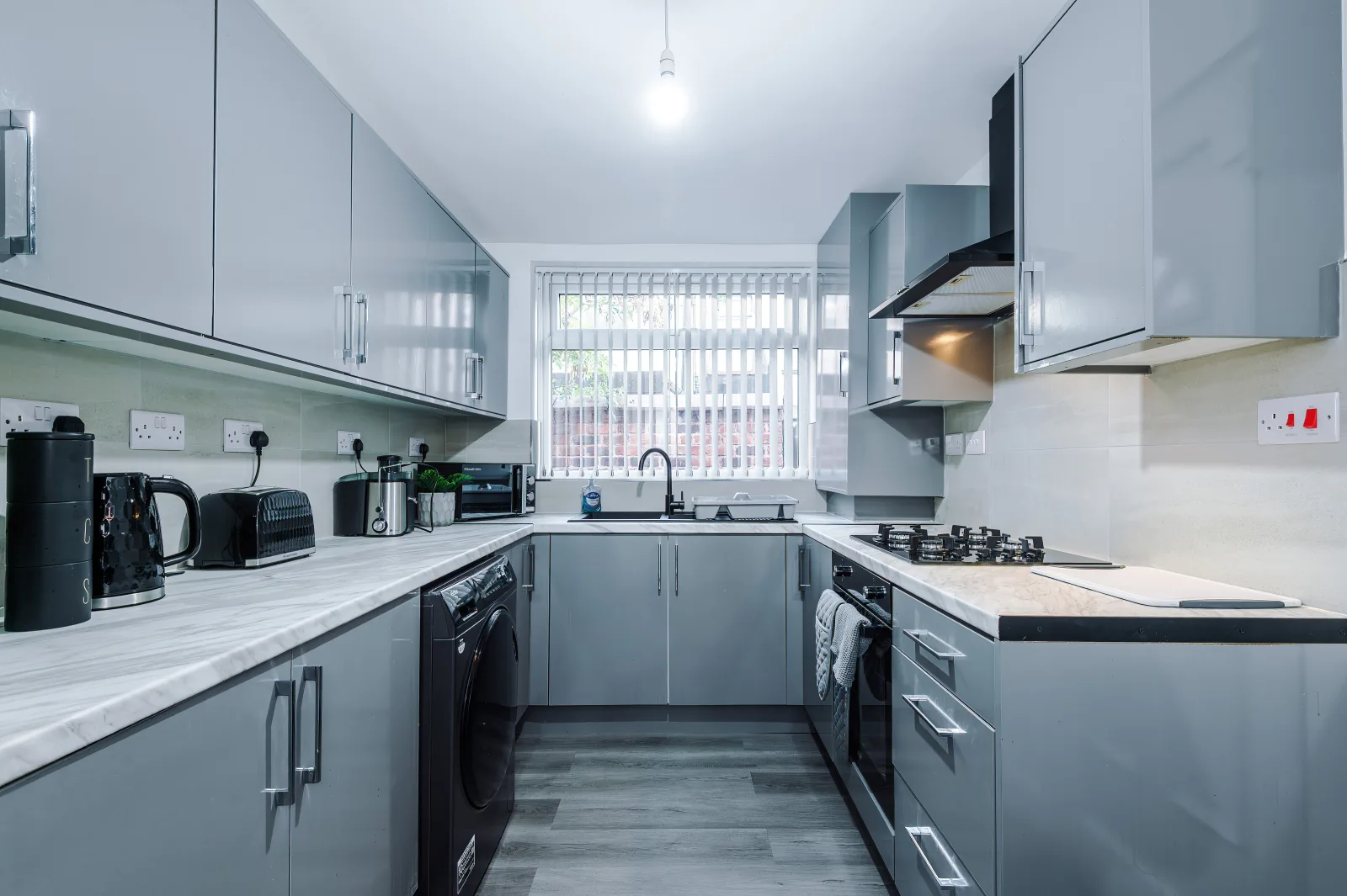 Fitted kitchen with grey units, gas hob and oven at 34 Beeston Street