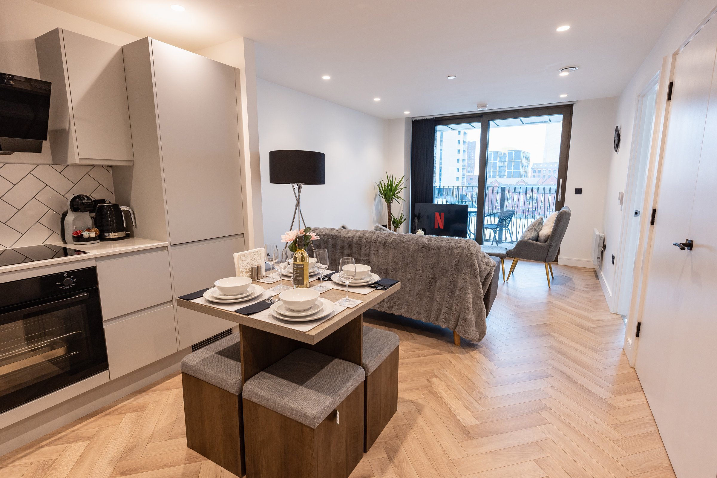 Dining table with four stools between the kitchen and the living room