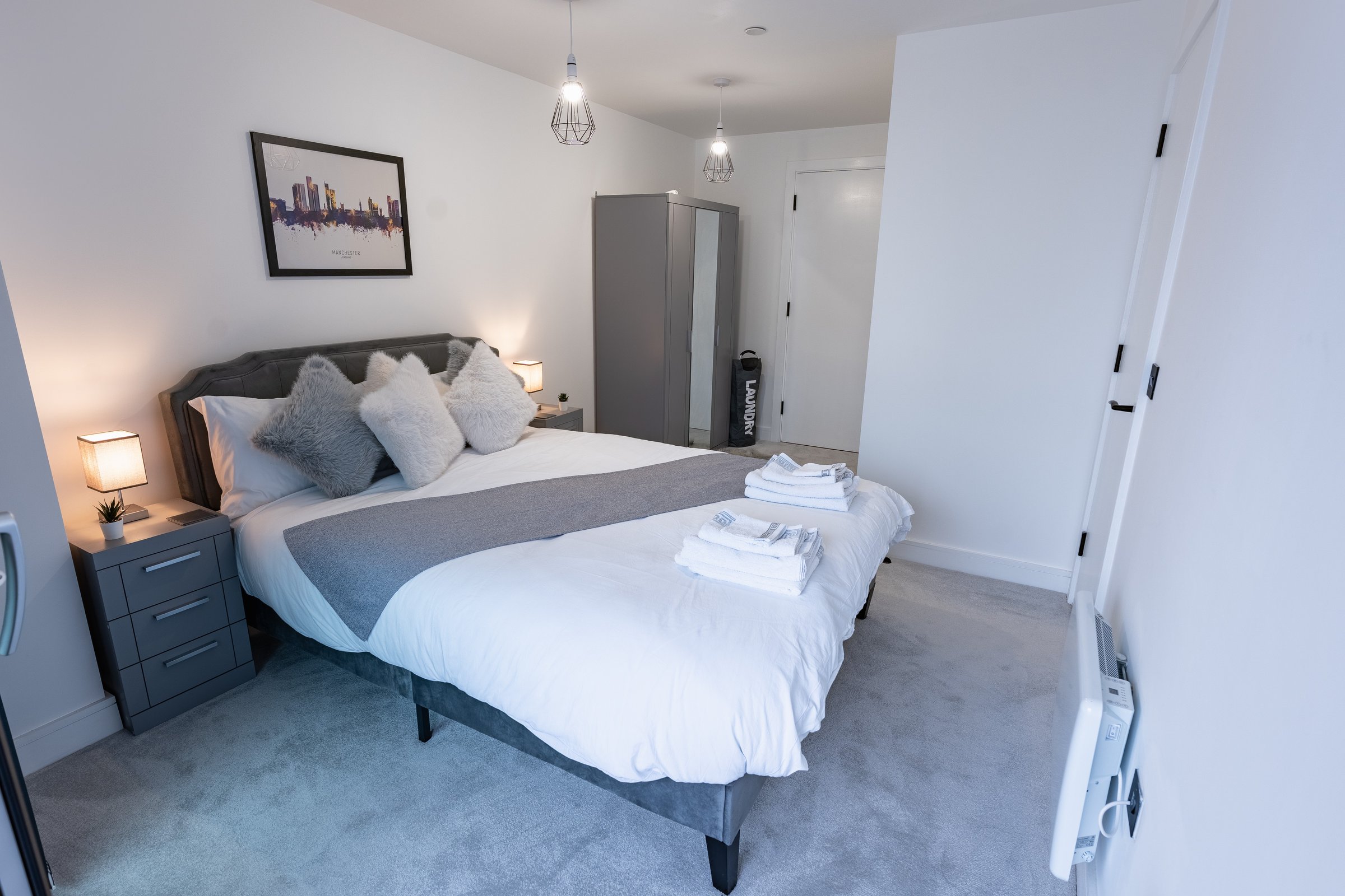 Bedroom with a made-up double bed, bedside tables and lamps