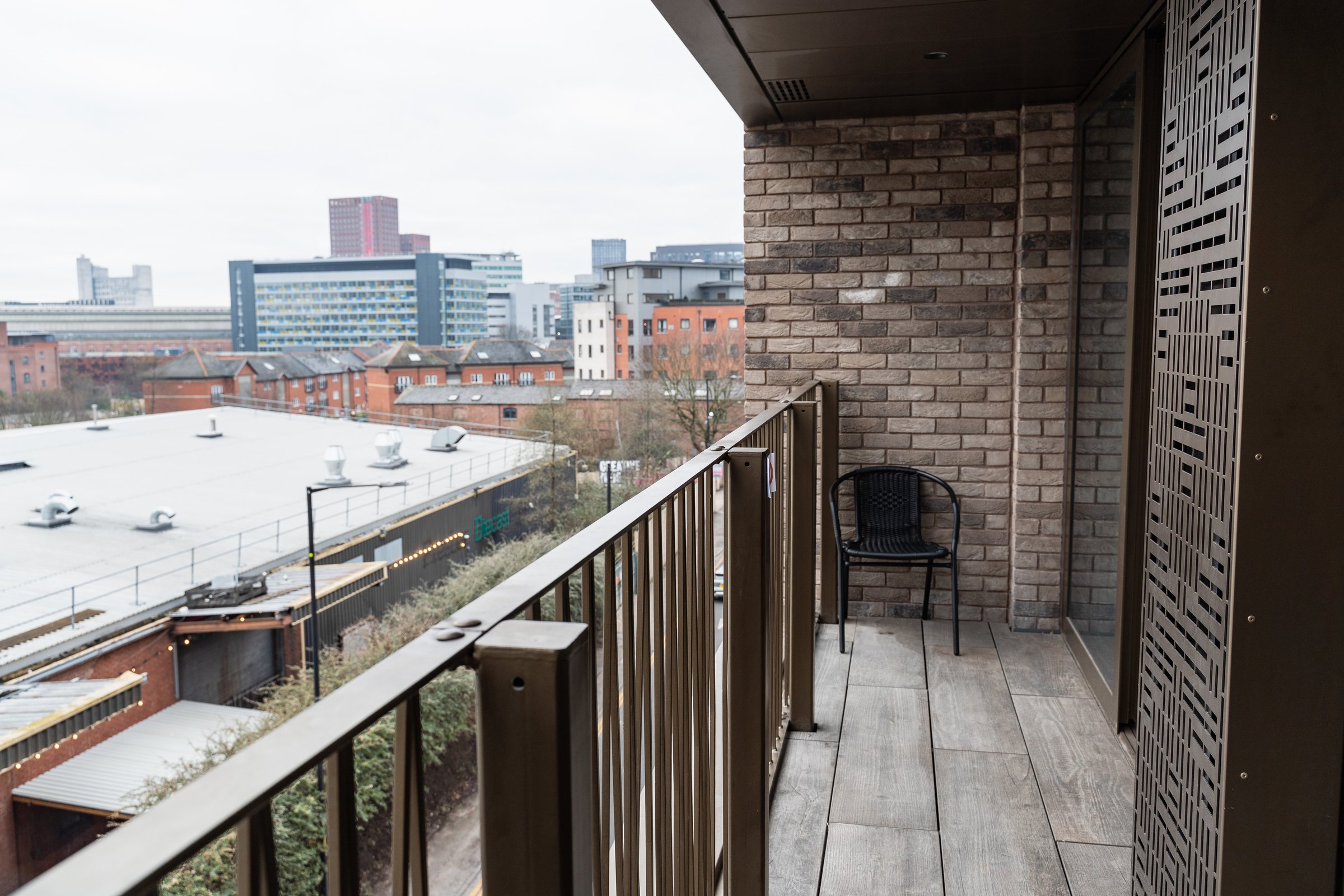 Balcony with a chair and views over the city rooftops
