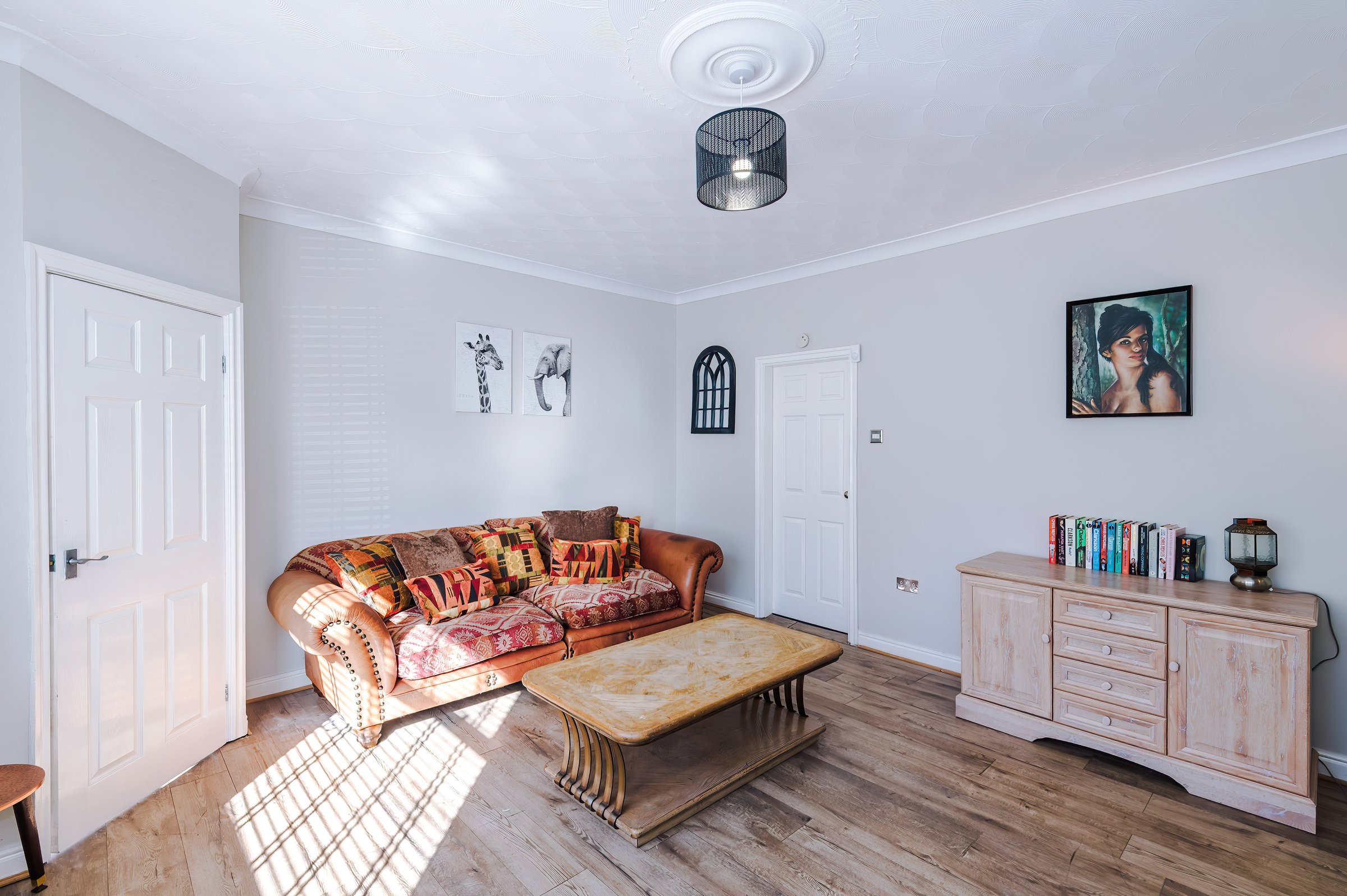 Living room with a patterned sofa, wooden coffee table and sideboard