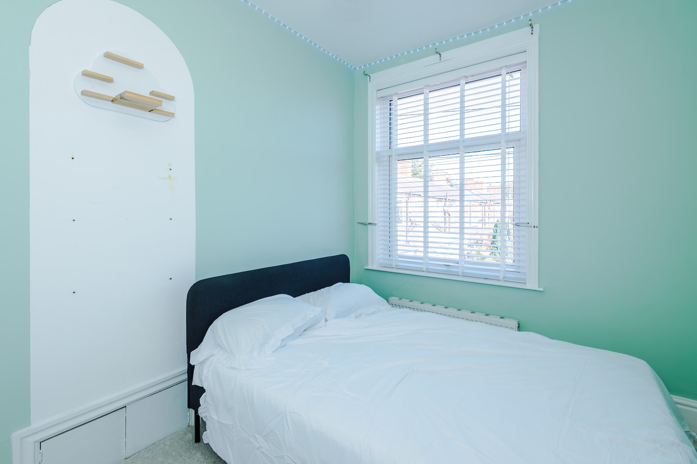 Second bedroom with a double bed and mint green walls