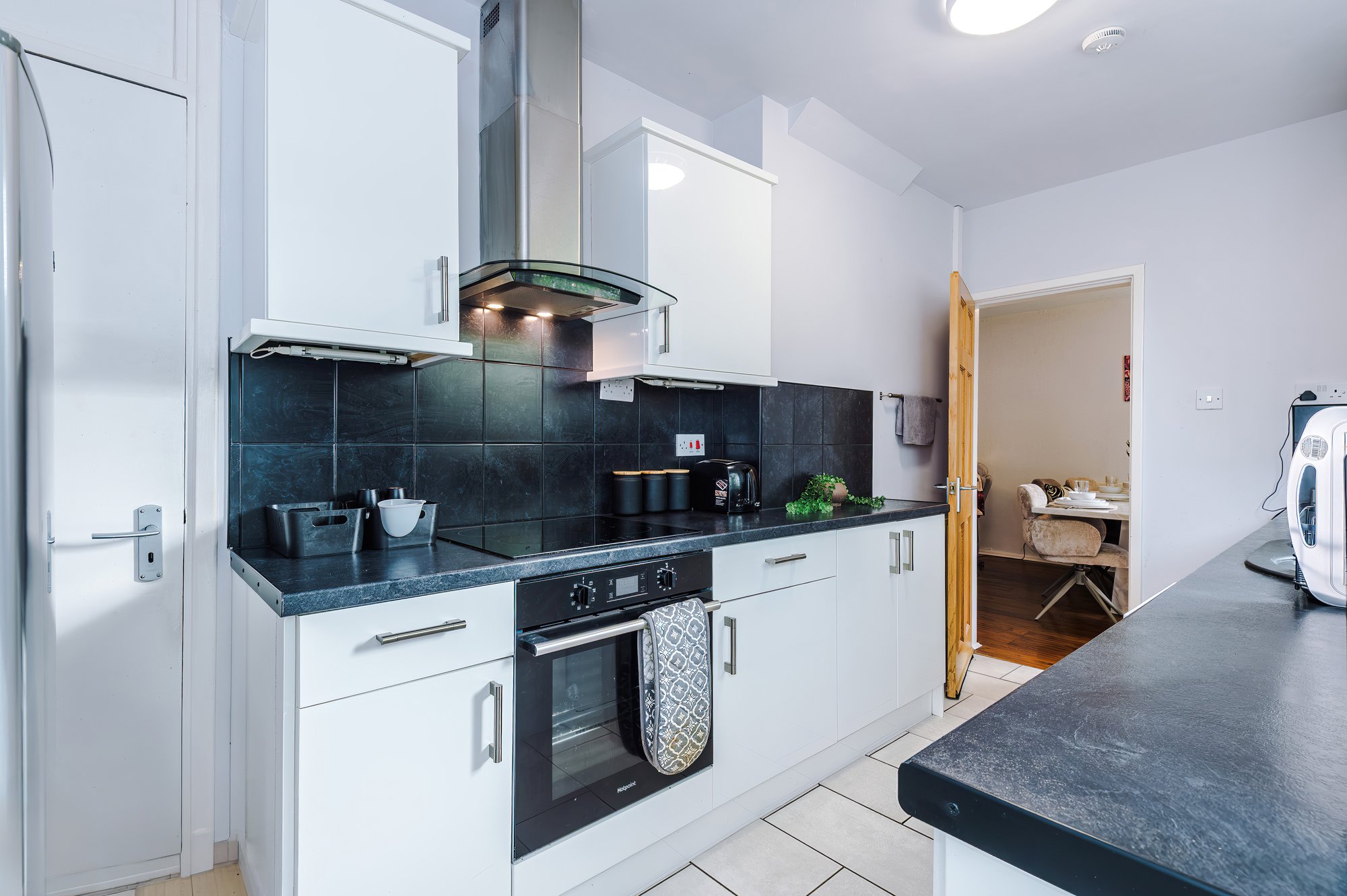 Kitchen with white units, oven and extractor hood