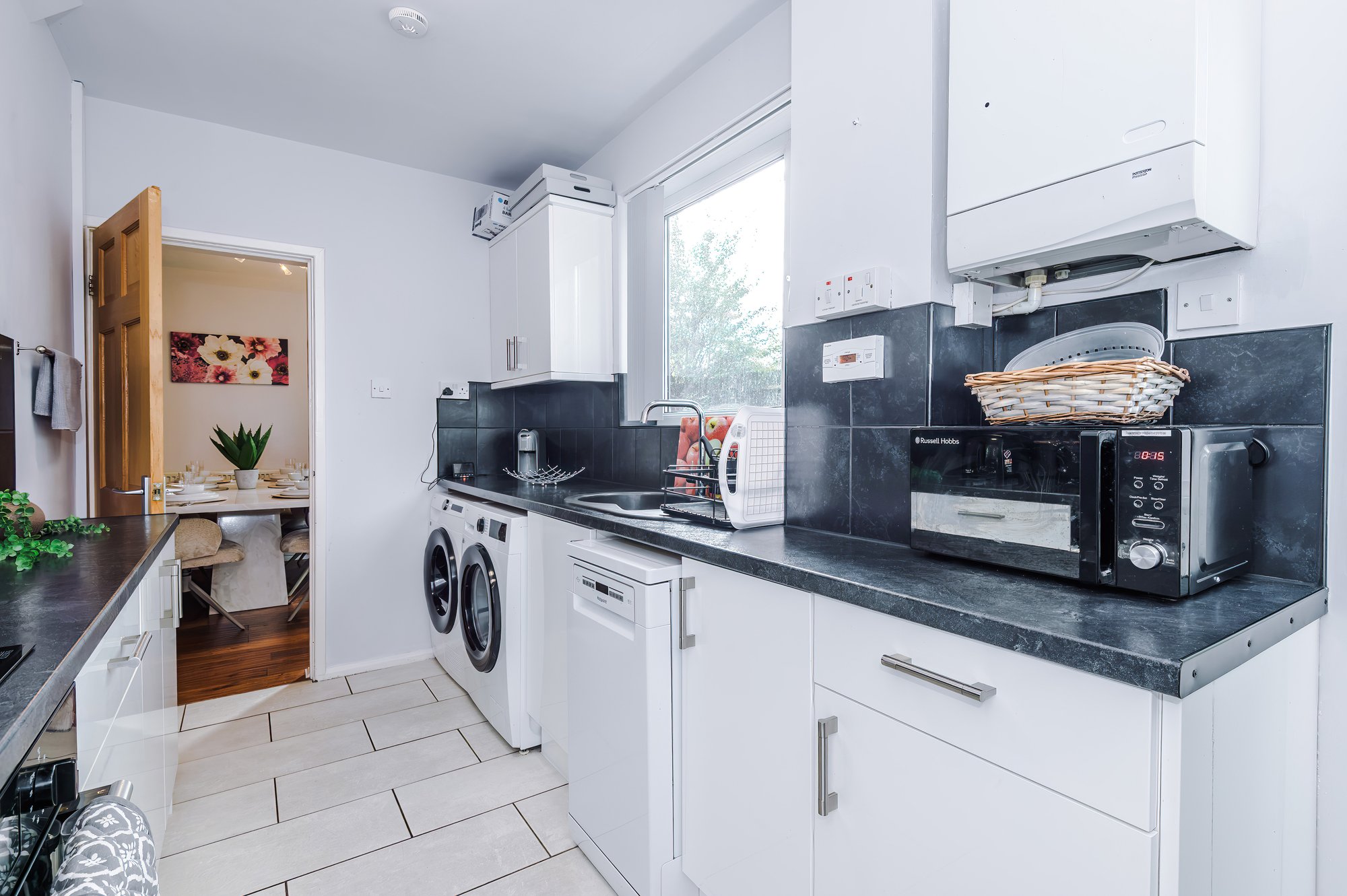 Kitchen with washing machine, dishwasher and microwave