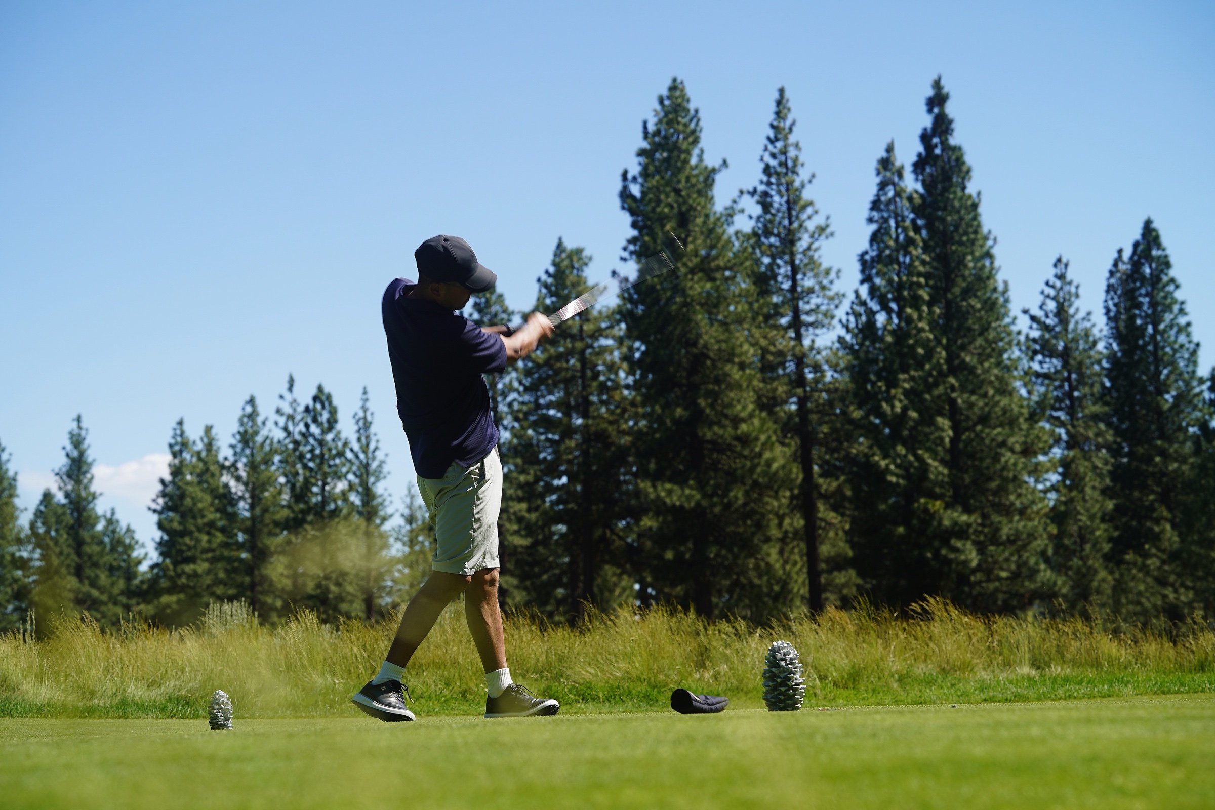 Golfer wearing PAYNTR shoes during a full swing on the course.