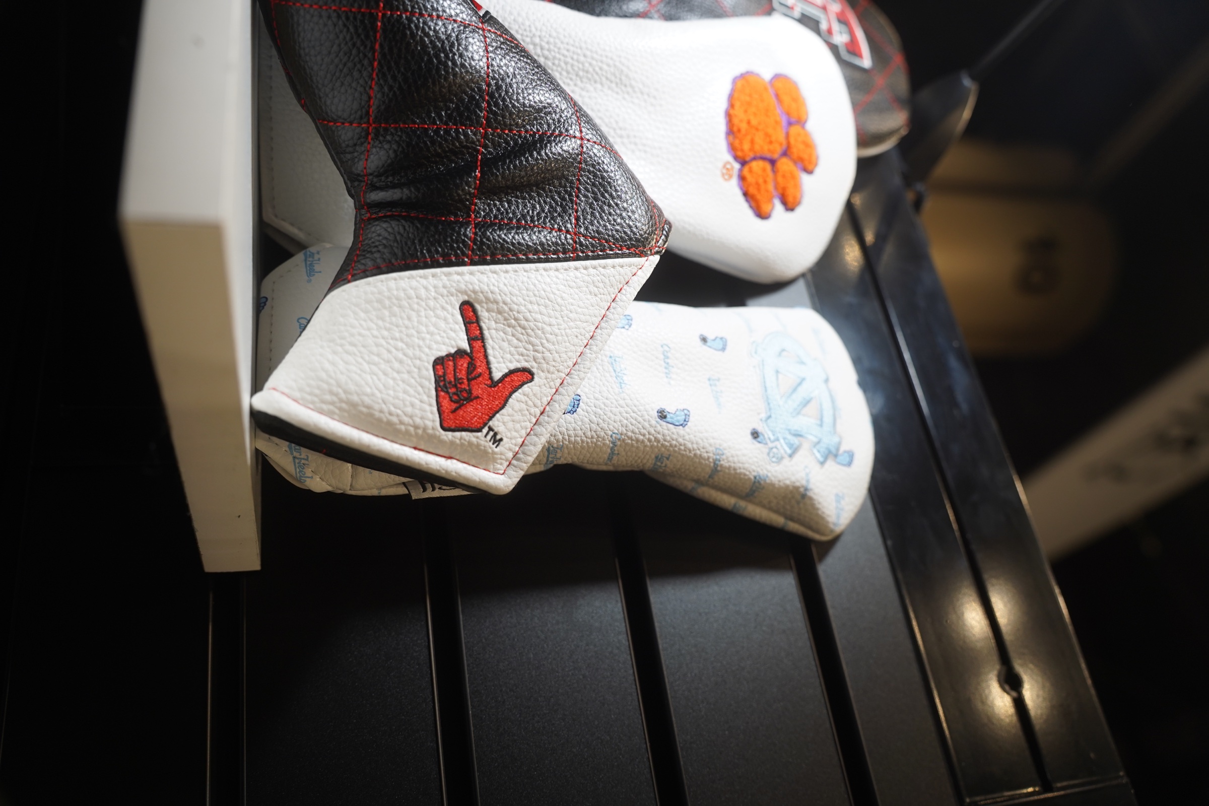 Embroidered golf headcovers arranged on a dark product display.