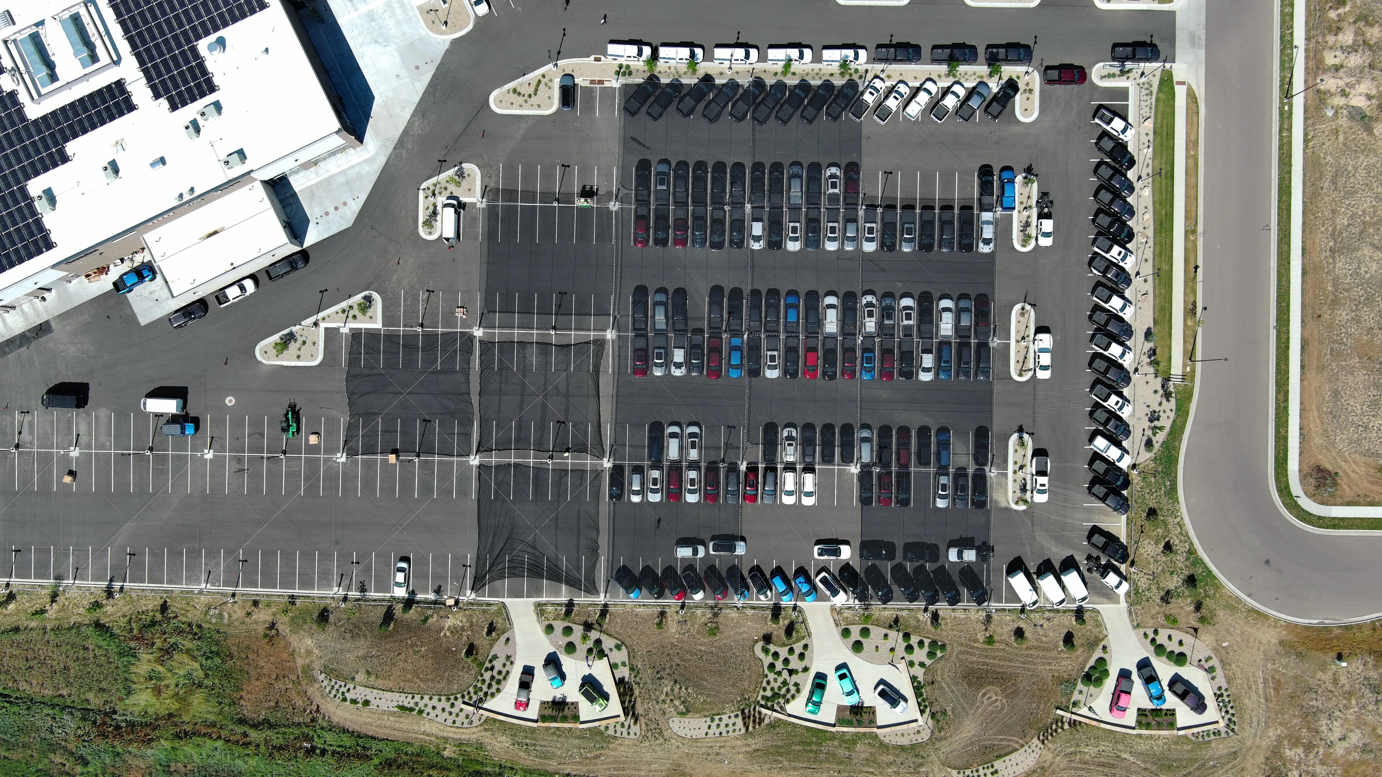 Aerial view of car dealership with hail netting installed over lot